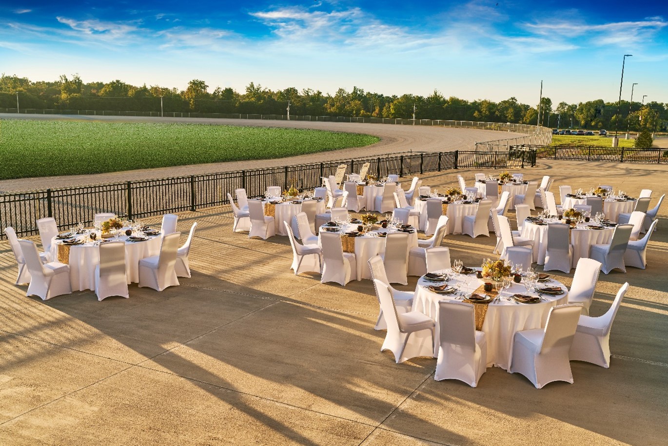 Tables and chairs set up for a reception in front of the race track.