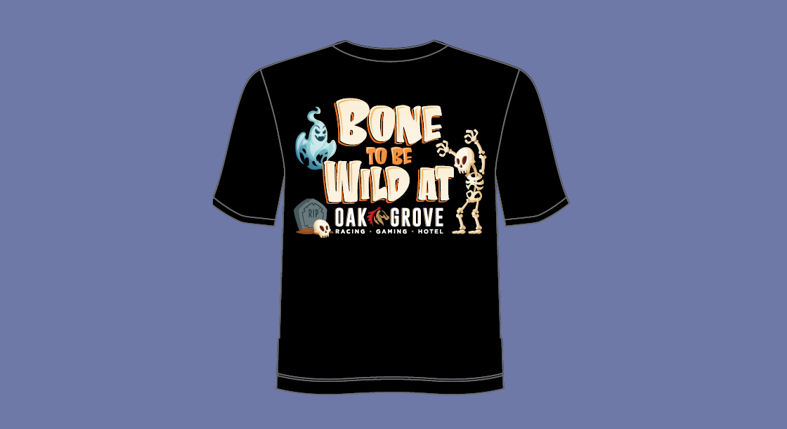 A black t-shirt with "Bone To Be Wild" and the Oak Grove logo written on it with a ghost, skeleton, and tombstone around the words, in front of a blue/gray background.